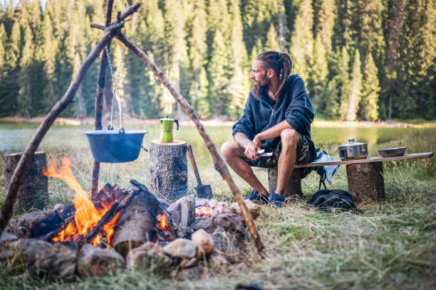istock Man on camping cooking at the campfire. 1477652638