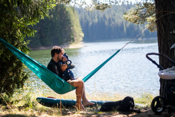 istock Father embracing his baby boy on a hammock. 1477652690