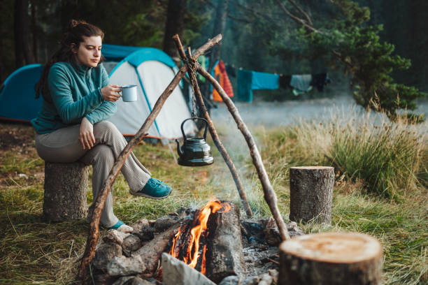 istock Young woman having her morning coffee on a camping vacation. 1477652731