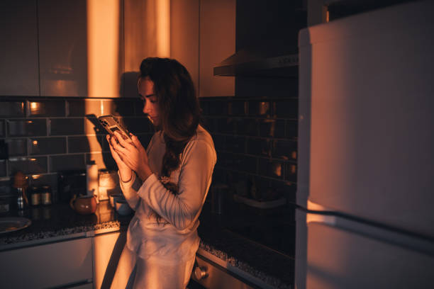 istock Beautiful girl in the kitchen using a smartphone. 1477652763