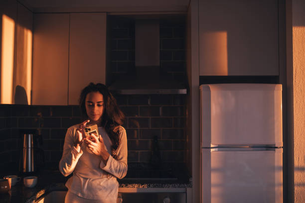 istock Beautiful girl in the kitchen using a smartphone. 1477652765
