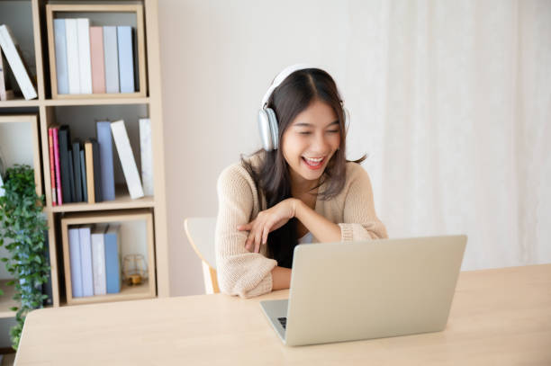 istock Young asian woman wearing headset while working on computer laptop at house. Work at home, Video conference, Video call, Student learning online class 1477653118