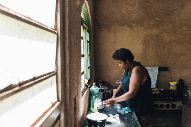 istock Woman preparing food in modest kitchen 1477653670
