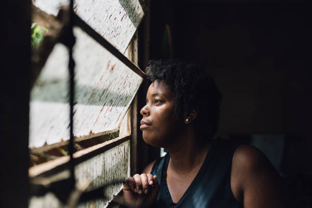 istock Woman looking in the windowpane 1477654847