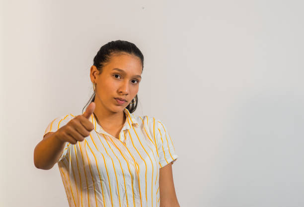 latin woman in photo studio with colored backgrounds, using books, phones and different gestures of her face