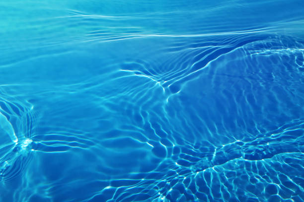 istock Defocus blurred transparent blue colored clear calm water surface texture with splashes and bubbles. Trendy abstract nature background. Water waves in sunlight with copy space. Blue water shine 1477661839