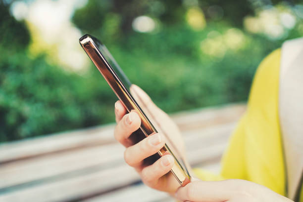 istock Woman looking at smartphone and green blur background 1477665245