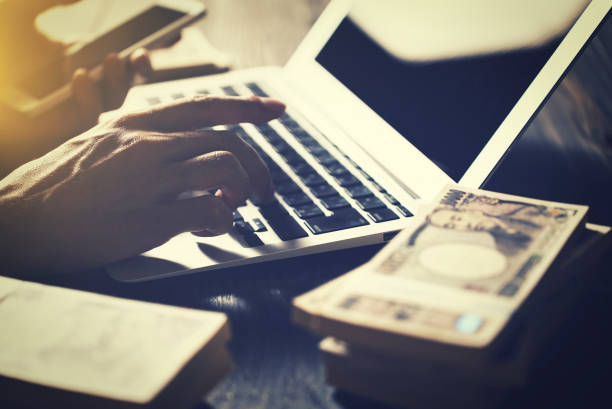 istock Man working with Japanese wads and laptop 1477666445
