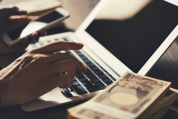 istock Man working with Japanese wads and laptop 1477666453