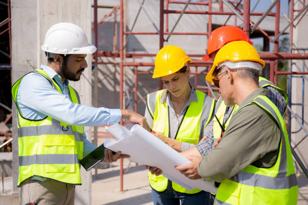istock Team group of contractor and architect with foreman explaining about scheme building site for planning project to worker and looking blueprint, construction site, development and structure. 1477667636