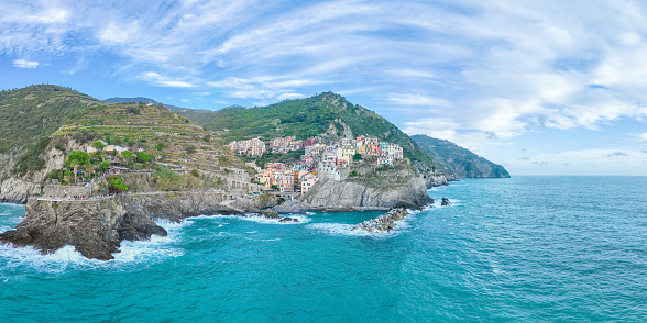 Aerial panorama top view of Manarola colorful fishing village one of five Cinque Terre national park, sequence of hill cities along the coastline of Ligurian Sea in Italy. Popular travel destination.