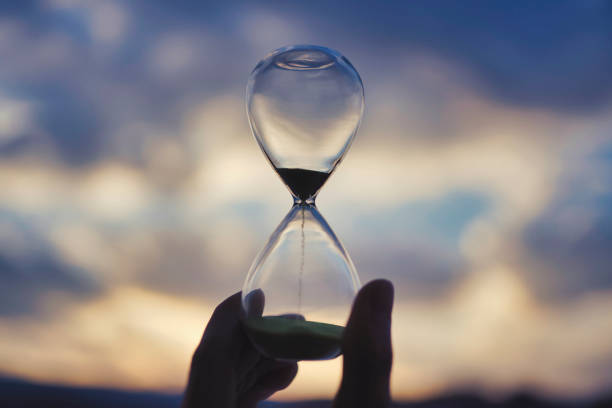istock Glass hourglass and sunset sky 1477669131
