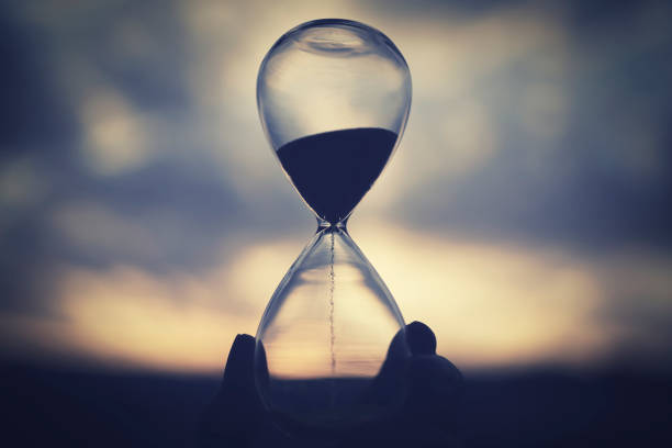 istock Glass hourglass and sunset sky 1477669360