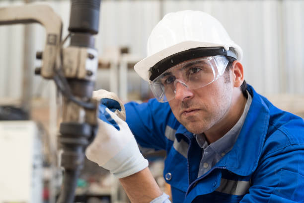 istock Male engineer maintenance automatic welding robotic arm machine in factory. Male technician worker checking, repair old robot arm machine in workshop 1477672340