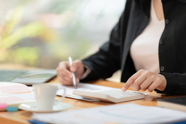 istock Close up hands businesswoman doing finances with using calculator and writing note in office. 1477674751