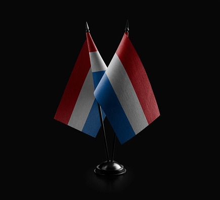 Small national flags of the Netherlands on a black background.