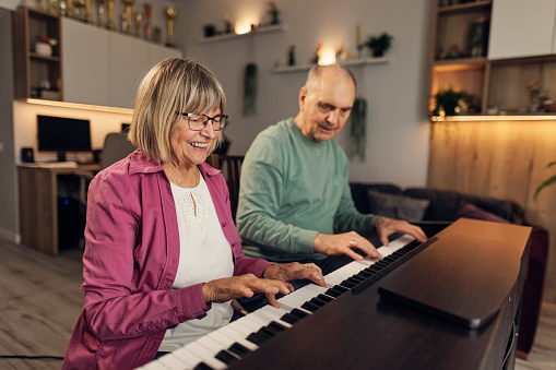 Senior couple enjoy playing the piano in the living room.
Shot with Canon R5