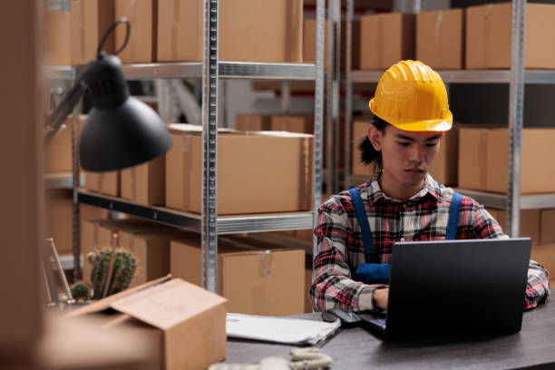 istock Delivery service worker managing parcel shipment on laptop 1477679168