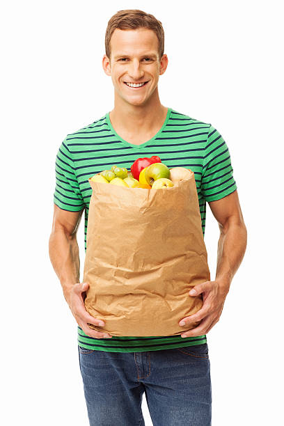 istock Young Man Carrying Bag Of Groceries - Isolated 147767921