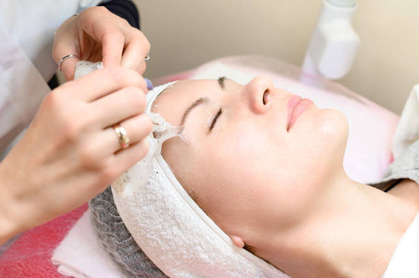istock Removing a moisturizing mask from the face in a cosmetology office. 1477689029