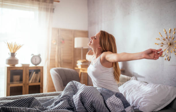 istock Woman relaxing on a bed and stretching hands 1477690029