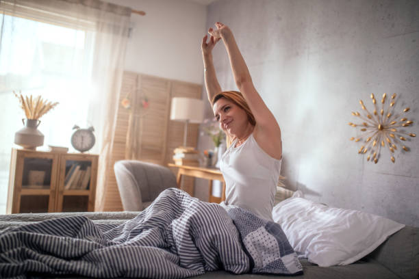 istock Woman relaxing on a bed and stretching hands 1477690035