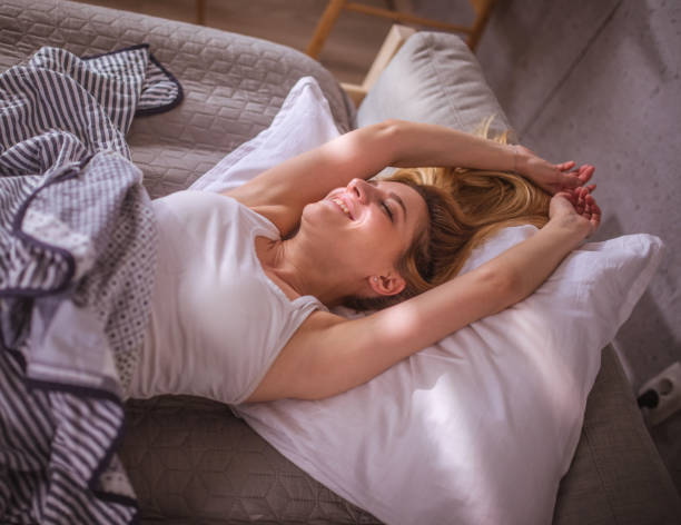 istock Woman relaxing on a bed and stretching hands 1477690087