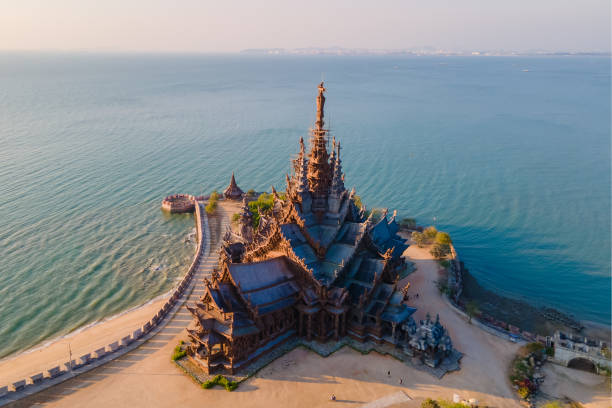 sanctuary of truth, pattaya, thailand, wooden temple by the ocean at sunset on the beach of pattaya - pattaya imagens e fotografias de stock