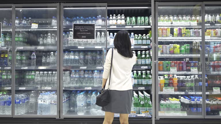 4K Woman Picking Bottle Of Water From Refrigerated Section In Supermarket