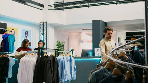 istock Retail worker helping customer to buy shirts at mall 1477702091