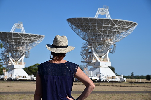 Narrabri, Nsw- MAR 03 2023:Australian woman looking at the Telescope Compact Array near Narrabri NSW, that observe star formation, the late stages of stars lives, supernovae and magnetic fields.