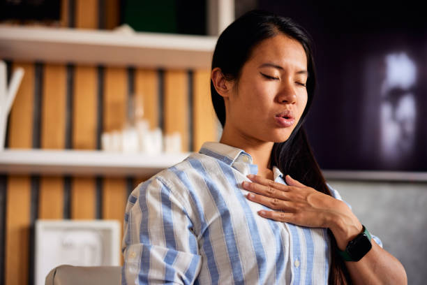 istock A focused Asian woman practicing breathing techniques in the early morning at home. 1477705683