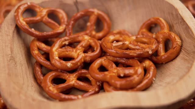 Bavarian pretzel crackers falling into a wooden bowl