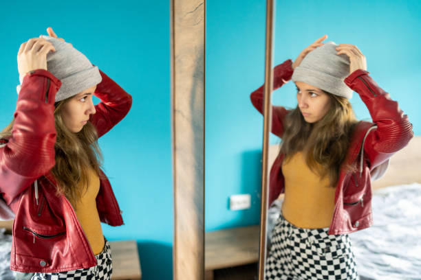 istock Young woman adjusting her hat in front of a mirror 1477720477