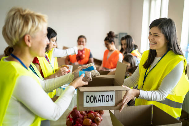 istock Volunteers packing donation box with food 1477722165