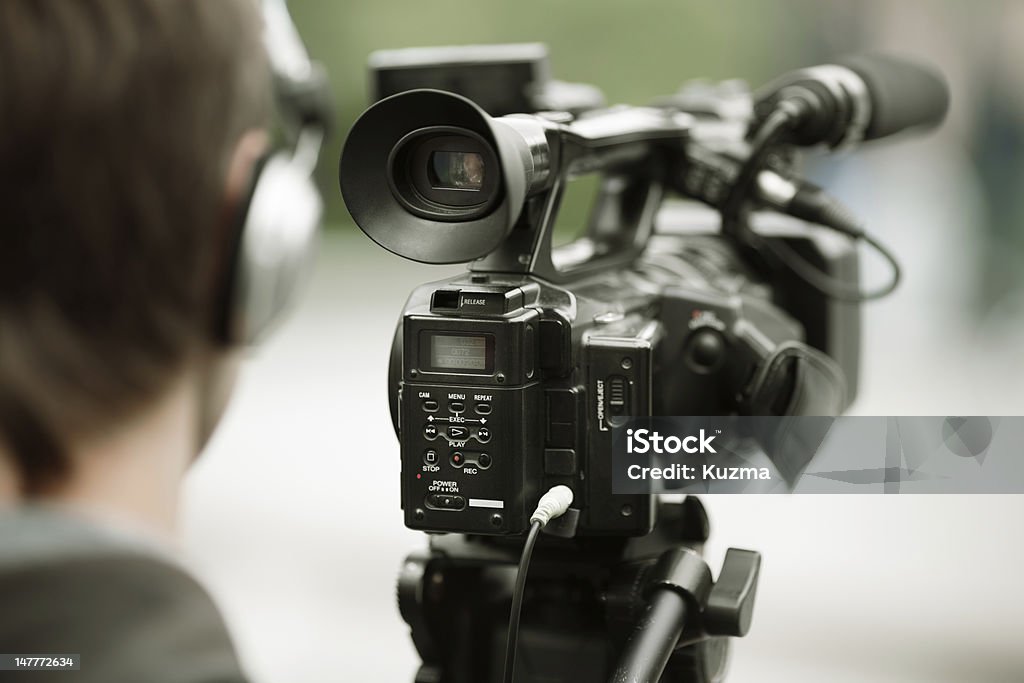 news shooting professional camcorder on the tripod, selective focus on nearest part Reportage Stock Photo