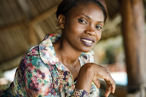 Portrait of happy black woman on a terrace looking at camera.