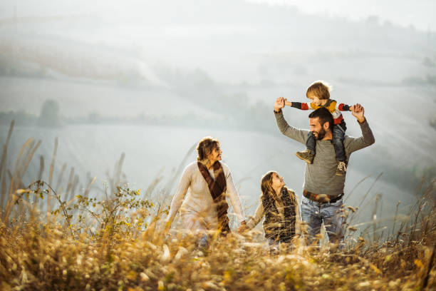 istock Carefree parents having fun while walking with their kids on a field. 1477729254