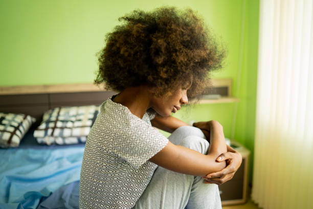 istock A forlorn woman sitting lonely on her bed 1477730980