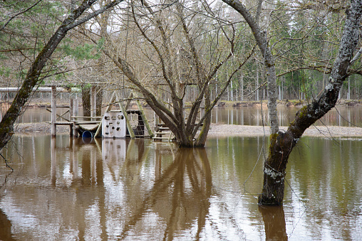 a flooded river where trees and playhouses can be seen in the water in spring