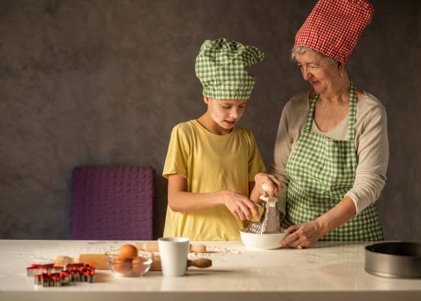 Grandma and grandson make pizza, grandma teaches grandson.