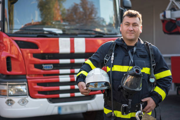 istock Firefighter carrying his gear and looking at camera 1477733506