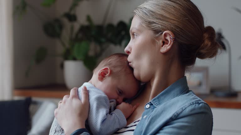 young mother caring for baby at home calming tired newborn gently soothing restless infant nurturing motherhood