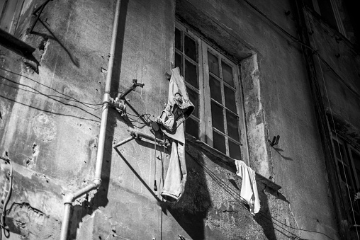 jeans hanging on the wall of a house with a window denote a hasty and Roccambolesque departure