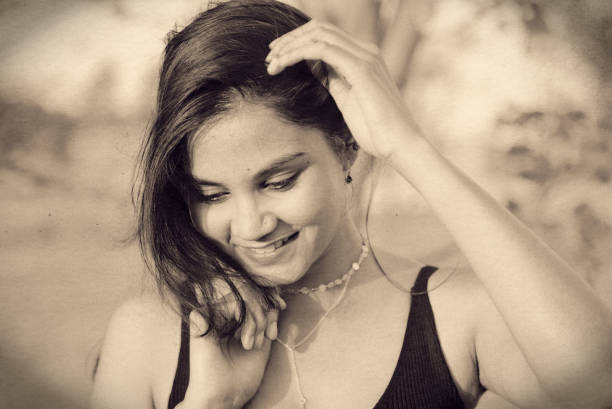 Indian Asian young female monochrome black and white stylised treated close up portrait of smiling emotion  in outdoors daylight stock photo