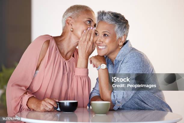 Senior Women Bonding Or Whispering Secrets In Coffee Shop Restaurant Or Cafe And Funny Gossip News Or Story Smile Happy Or Retirement Elderly Friends Whisper In Ear Or Sharing In Rumor Spread Stock Photo - Download Image Now