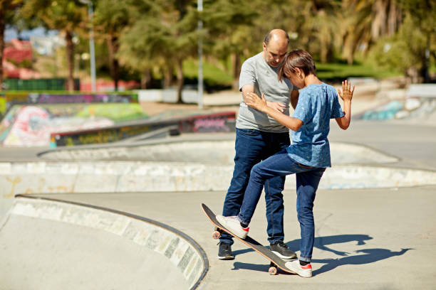 istock Father teaching young son how to skate into bowl 1477741995