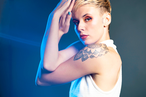 Studio shoot of an urban young Caucasian woman, with short hair, and tattoos