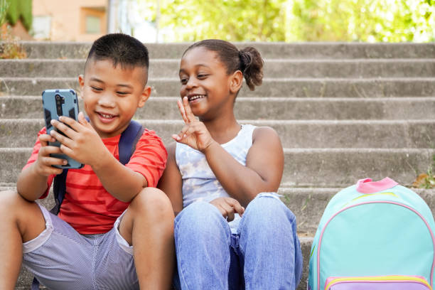 istock Happy multiethnic children using mobile phone for vlogging 1477755808