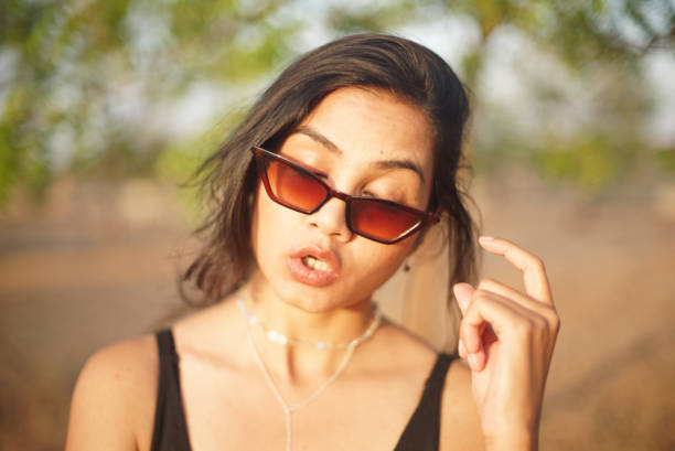 Indian Asian young female close up portrait of explaining something facial gesture with fingers  in outdoors daylight stock photo
